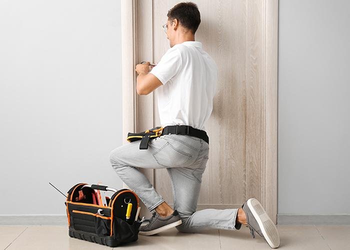 Artisan serrurier au travail sur une porte